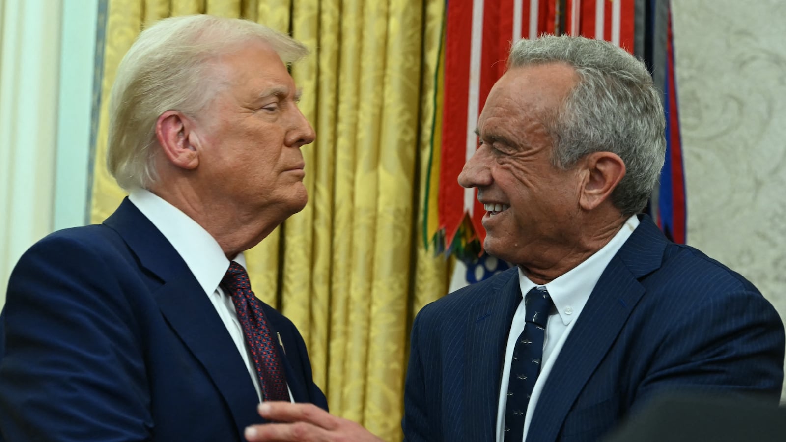 The new US Secretary of Health and Human Services Robert F. Kennedy Jr., shakes hands with US President Donald Trump after a swearing in ceremony in the Oval Office of the White House in Washington, DC, on February 13, 2025. (Photo by ANDREW CABALLERO-REYNOLDS / AFP)