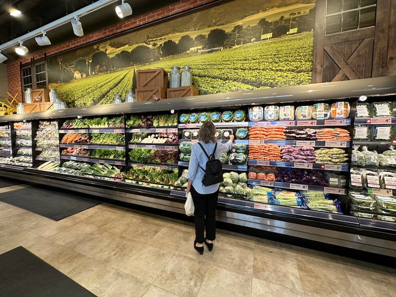 TORONTO, ON - May 12 - A shopper reaches for a container of lettuce at a Farm Boy grocery store in the YongeEglinton area in Toronto. Lance McMillan/Toronto StarMay-12-2023        (Lance McMillan/Toronto Star via Getty Images)